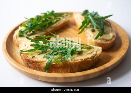 Sandwich de tranches de pain grillées avec tartinade de houmous classique de pois chiches, graines de citrouille rôties et arugula fraîche Banque D'Images