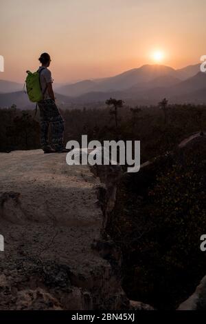 Silhouette d'une jeune femme contemplant le coucher du soleil à randonneur Pai Canyon (Kong Lan), le nord de la Thaïlande. Banque D'Images