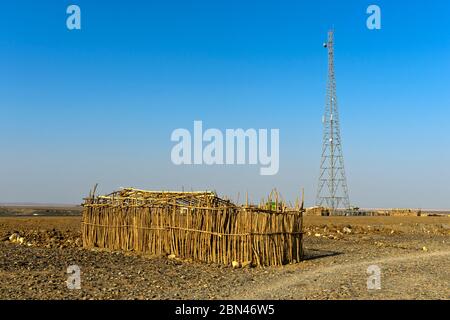Tour à micro-ondes, en face d'un abri traditionnel des nomades Afar, Hamadela, Danakil Dépression, province d'Afar, Éthiopie Banque D'Images