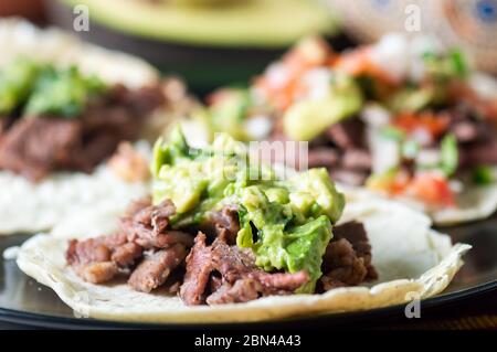 Tacos à la carne mexicaine asada, tacos à la viande littéralement grillés. Il s'agit de bœuf haché grillé servi sur des totillas de maïs mou avec de la salsa verde et du pico de ga Banque D'Images