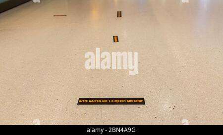 Gardez le panneau de distance au sol du sous-sol de Stachus (gare des transports publics avec magasins et restaurants). Pour rappeler aux gens de garder la distance. Banque D'Images