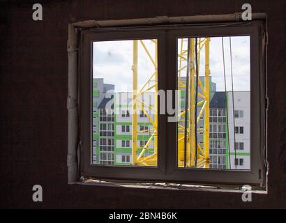 Bruit élevé du chantier de construction immission dans un cadre ouvert de fenêtre en pvc blanc, vue à travers. Banque D'Images