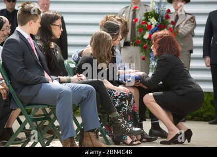 Claire M. Grady, sous-secrétaire intérimaire de la sécurité intérieure, rend hommage à la famille de Christopher T. Bacon, un agent de la patrouille frontalière américaine, avec le drapeau américain lors d'un service funéraire à Grand Forks, Dakota du Nord, le 14 juin 2018, après la mort de Bacon dans un accident de voiture. Banque D'Images
