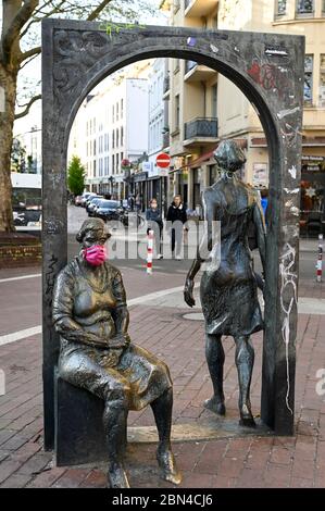 ALLEMAGNE, Hambourg, Ottensen, Corona virus, COVID-19 , Ottenser Torbogen, deux femmes sculpture de l'artiste Doris Waschk-Balz , quelqu'un a mis un masque de protection pour les protéger de Covid-19 Banque D'Images