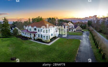 Vue aérienne au coucher du soleil sur les grandes maisons individuelles personnalisées avec porche couvert sur la côte est des États-Unis Banque D'Images