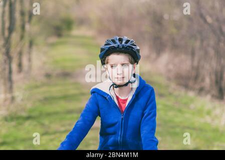 Portrait d'un enfant portant un vélo, sweat-shirt bleu Banque D'Images