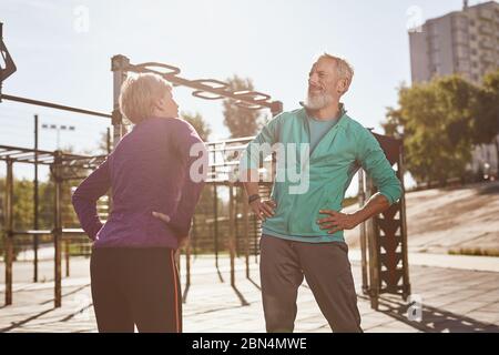 Personnes âgées et gymnastique. Un couple de famille mature et actif dans des vêtements de sport faisant des exercices du matin ensemble, en s'échauffant en se tenant debout à la Banque D'Images