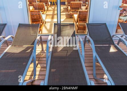 Rangées de chaises longues dans la piscine intérieure et à l'extérieur sur le patio. Banque D'Images