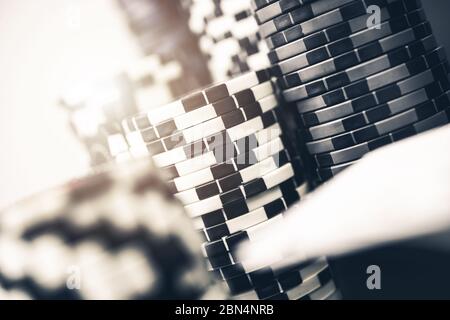 Gros plan de jetons de poker noir et blanc soigneusement empilés dans les grands pieux. Banque D'Images