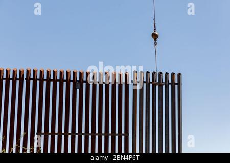 CALEXICO, Californie – le 28 juin 2019, les douanes et la protection des frontières (CBP) des États-Unis, en partenariat avec le U.S. Army corps of Engineers (USACE), ont commencé l'installation de panneaux sur environ 11 milles de nouveau système de mur frontalier à la place de conceptions démodées et démodées à Calexico, Californie dans le secteur de San Diego de la patrouille frontalière des États-Unis (USBP). Ce projet comprendra la construction de bornes en acier de 30 pieds de haut et des améliorations technologiques. Banque D'Images