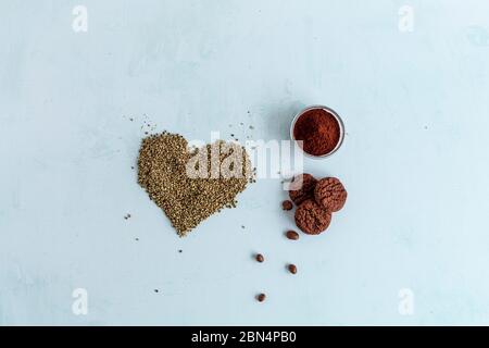 Biscuits au cannabis CBD, cacao et graines de chanvre en forme de coeur sur fond clair. Marijuana médicinale dans les aliments. Banque D'Images