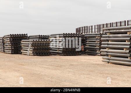 Les équipes de construction de Barnard Construction de Bozeman, Montana, matériel de scène nécessaire pour le projet de remplacement du mur frontalier de Santa Teresa près du port d'entrée de Santa Teresa. La zone de mise en scène, située sur le circuit abandonné Rio Grande à Santa Teresa, au Nouveau-Mexique, présente également un exemple réduit de ce à quoi ressemblera le mur de style bollard. Banque D'Images