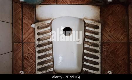 toilettes vieilles et poussiéreuses sales dans un bâtiment public abandonné. Salle d'hygiène en ruines Banque D'Images