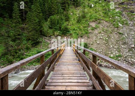 Passerelle en bois traversant la rivière Lech, sur le sentier Lechweg près de Bodenalpe, Lech, Autriche. Banque D'Images