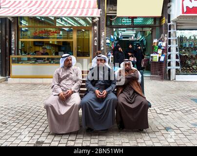 Koweït, Koweït : trois hommes arabes assis à proximité dans des vêtements traditionnels Banque D'Images