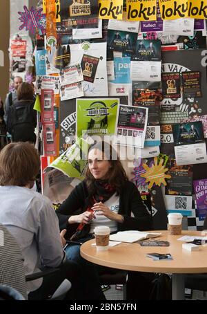 Austin, Texas : SXSW - 12 mars 2012 - couple parlant wihile avoir un café à une convention interactive attire des milliers de participants faisant de n'importe quel mur une occasion de placer des dépliants de marketing ©Marjorie Kamys Cotera / Daemmrich photos Banque D'Images