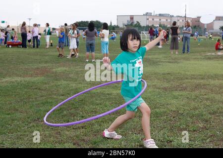 Austin, Texas Etats-Unis, 10 mai 2012: Une fille asiatique-américaine joue avec un hula hoop pendant le jour de campagne à son école. ©Marjorie Kamys Cotera/Daemmrich Photographie Banque D'Images