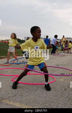 Austin, Texas Etats-Unis, 10 mai 2012: Un garçon noir joue avec un hula hoop pendant la journée de terrain à son école. ©Marjorie Kamys Cotera/Daemmrich Photographie Banque D'Images