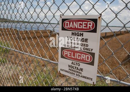 Austin, Texas USA, juin 2012 : panneau bilingue « haute tension » sur la clôture d'un projet solaire Webberville près d'Austin. L'installation est un système photovoltaïque à courant continu (DC) de 35 mégawatts sur 380 acres et produira annuellement plus de 50 000 MWh d'énergie solaire sans émission, suffisamment pour alimenter 5000 foyers. ©Marjorie Kamys Cotera/Daemmrich Photographie Banque D'Images