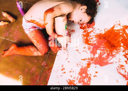 Une fille d'un an aime se salir avec la peinture et en faire un désordre. Banque D'Images