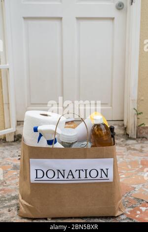 Un sac de don rempli de nourriture et de produits de nettoyage est livré à la maison pendant la pandémie de Covid-19/coronavirus Banque D'Images