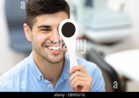 Patient et opticien effectuant un test oculaire en clinique Banque D'Images