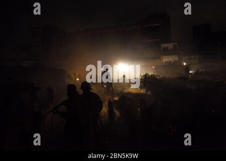 Les pompiers de Jakarta travaillent entre les débris après une bataille dans un quartier dense les membres de la brigade des pompiers de Jakarta refroidissent la zone, après qu'un accident d'incendie se propage et brûle des centaines de maisons dans un quartier dense à Penjaringan, dans le nord de Jakarta, Jakarta, Indonésie. Image d'archivage. 28 février 2011. Photo: Reynold Sumayku Banque D'Images