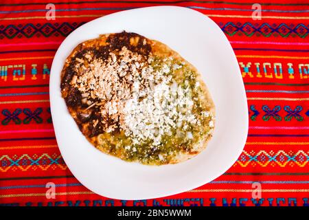 Sopes mexicains au fromage râpé et à la salsa verte, cuisine mexicaine épicée au mexique Banque D'Images