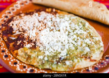 Sopes mexicains au fromage râpé et à la salsa verte, cuisine mexicaine épicée au mexique Banque D'Images