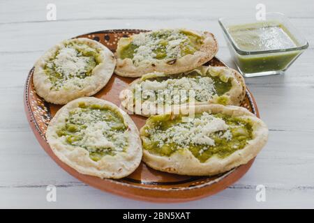 Sopes mexicains au fromage râpé et à la salsa verte, cuisine mexicaine épicée au mexique Banque D'Images