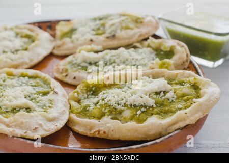 Sopes mexicains au fromage râpé et à la salsa verte, cuisine mexicaine épicée au mexique Banque D'Images