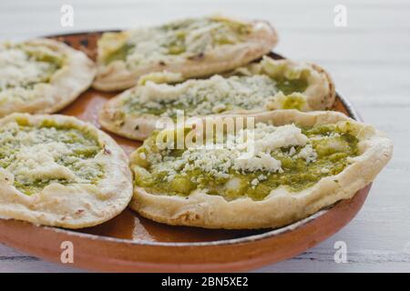 Sopes mexicains au fromage râpé et à la salsa verte, cuisine mexicaine épicée au mexique Banque D'Images