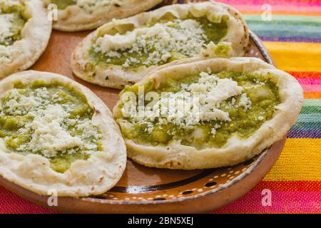 Sopes mexicains au fromage râpé et à la salsa verte, cuisine mexicaine épicée au mexique Banque D'Images