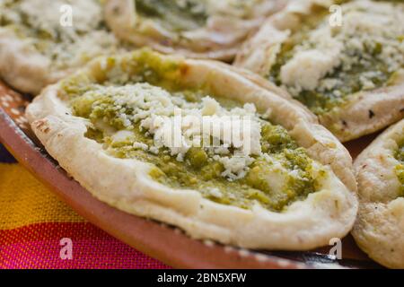 Sopes mexicains au fromage râpé et à la salsa verte, cuisine mexicaine épicée au mexique Banque D'Images