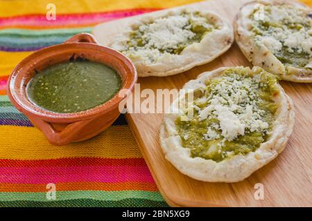 Sopes mexicains au fromage râpé et à la salsa verte, cuisine mexicaine épicée au mexique Banque D'Images