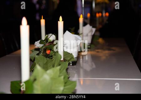 Table de dîner aux chandelles avec papier de soie sur un verre Banque D'Images