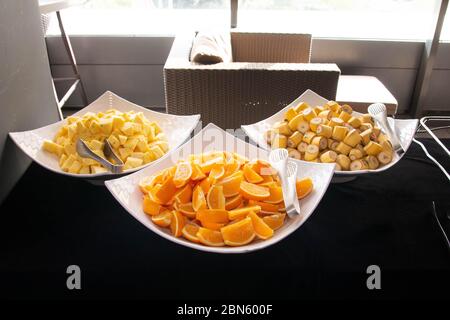 Tranchés d'oranges, de bananes et d'ananas sur un grand bol de buffet Banque D'Images