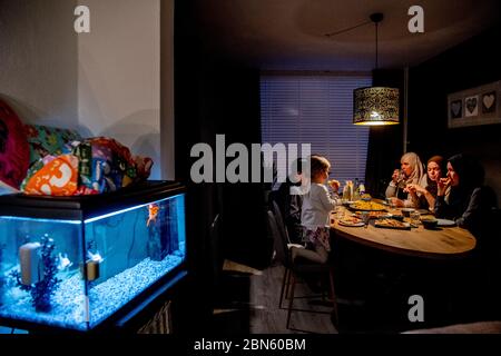 Rotterdam, pays-Bas. 13 mai 2020. Une famille à la table ayant le repas de l'iftar après le coucher du soleil pendant le mois islamique à jeun du Ramadan, le mois le plus sacré du calendrier islamique. Crédit : SOPA Images Limited/Alamy Live News Banque D'Images