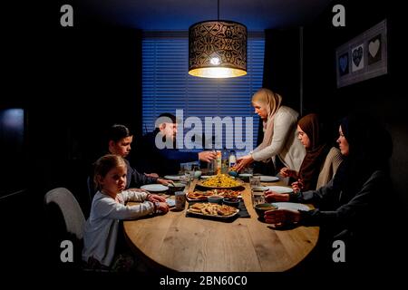 Rotterdam, pays-Bas. 13 mai 2020. Une famille à la table ayant le repas de l'iftar après le coucher du soleil pendant le mois islamique à jeun du Ramadan, le mois le plus sacré du calendrier islamique. Crédit : SOPA Images Limited/Alamy Live News Banque D'Images