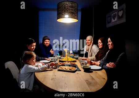 Rotterdam, pays-Bas. 13 mai 2020. Une famille à la table ayant le repas de l'iftar après le coucher du soleil pendant le mois islamique à jeun du Ramadan, le mois le plus sacré du calendrier islamique. Crédit : SOPA Images Limited/Alamy Live News Banque D'Images