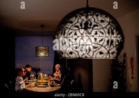 Rotterdam, pays-Bas. 13 mai 2020. Une famille à la table ayant le repas de l'iftar après le coucher du soleil pendant le mois islamique à jeun du Ramadan, le mois le plus sacré du calendrier islamique. Crédit : SOPA Images Limited/Alamy Live News Banque D'Images