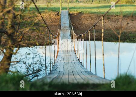 Ancien pont suspendu en bois au-dessus de la rivière. Photo un jour d'été. Traversée de la rivière pour les personnes Banque D'Images