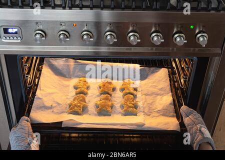 Pâtisserie homme de pain d'épice au four, femme faisant maison de pain d'épice homme biscuits dans le four Banque D'Images
