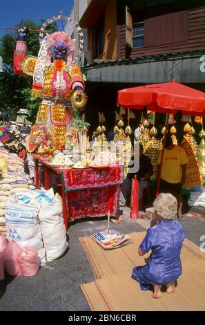 Thaïlande: Une femme âgée visite un sanctuaire de rue au Festival végétarien de Phuket, à Phuket. Le Festival végétarien est un festival religieux chaque année Banque D'Images