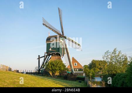 Moulin à vent traditionnel hollandais sur une digue à la lumière du soir. Mill est appelé 'Oukoopse Molen' et se trouve près de la ville de Gouda, Hollande. Banque D'Images