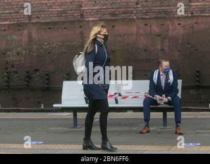 WIMBLEDON LONDRES, 13 mai 2020. ROYAUME-UNI. Les navetteurs portant des masques faciaux sur la plateforme de la gare de Wimbledon mercredi matin. Le Premier ministre Boris Johnson a appelé les travailleurs qui ne peuvent pas travailler de chez eux à retourner au travail dans la mesure du possible lors d'un discours télévisé national dimanche sur l'assouplissement des règles de verrouillage actuelles. Crédit : amer ghazzal/Alay Live News Banque D'Images