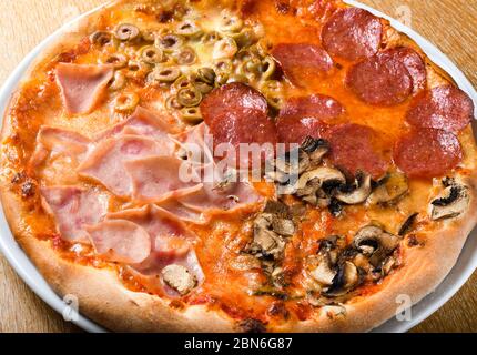 Pizza quattro stagioni est une variété de pizza dans la cuisine italienne qui est préparée en quatre sections avec des ingrédients variés, avec chaque section réprime Banque D'Images
