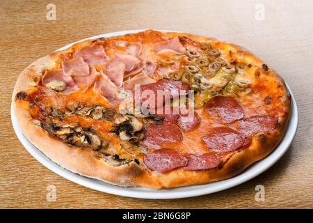 Pizza quattro stagioni est une variété de pizza dans la cuisine italienne qui est préparée en quatre sections avec des ingrédients variés, avec chaque section réprime Banque D'Images