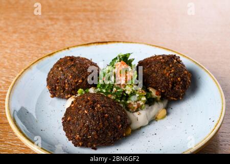 Le falafel est une boule frite ou une patty plate ou en forme de beignet, faite de pois chiches moulus, de fèves fava, ou les deux. Herbes, épices, oignon. Pâques moyennes Banque D'Images