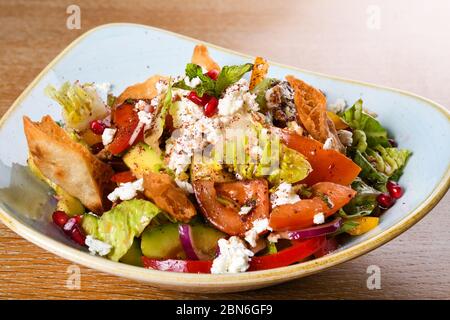 Fattoush est une salade Levantine faite de morceaux de khubz grillés ou frits, combinés avec des légumes verts et autres légumes, tels que des radis et des tomates Banque D'Images